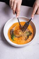 Plate with fried chicken and carrot and potato puree and female hands with cutlery photo