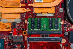 a motherboard with intricate circuit patterns, RAM modules, and various electronic components photo