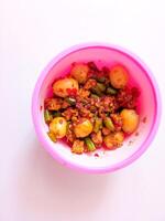 a bowl of balado quail eggs and tempeh ready to eat isolate on white photo