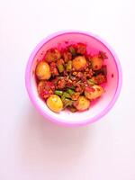 a bowl of balado quail eggs and tempeh ready to eat isolate on white photo