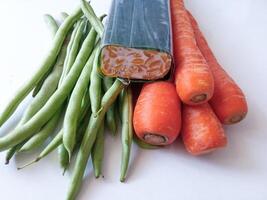 pile of green beans and carrots and tempeh isolate on white photo