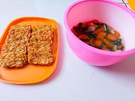 Fried tempeh and a bowl of spinach and carrots are ready to eat photo