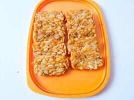 Fried tempeh is neatly lined up on a plate isolated on white photo