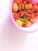 a bowl of balado quail eggs and tempeh ready to eat isolate on white photo