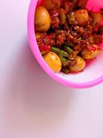 a bowl of balado quail eggs and tempeh ready to eat isolate on white photo