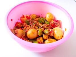 a bowl of balado quail eggs and tempeh ready to eat isolate on white photo