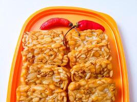 Fried tempeh is neatly lined up on a plate isolated on white photo