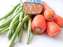 pile of green beans and carrots and tempeh isolate on white photo