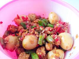 a bowl of balado quail eggs and tempeh ready to eat isolate on white photo