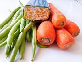 pile of green beans and carrots and tempeh isolate on white photo