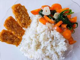 a plate of rice with tempeh and vegetables ready to eat isolate on white photo