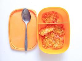 Corn fritters are located in a lunch box complete with a spoon on a white background photo