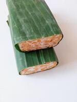 tempeh wrapped in banana leaves isolate on white photo