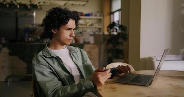 Programmer Or Software Developer Working With Laptop In Cafe, Holding Smartphone In Hand video