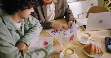 Business Partners Meeting In Coffee Shop And Discussing Marketing Reports, Closeup View Of Hands video