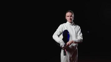 Professional Fencer In Uniform Holding Fencing Mask In Hands, Portrait In Black Background video