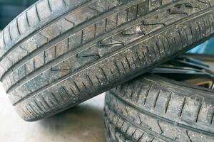 Tire workshop and change old wheel on the car. Old tire of a car, Danger of using an old tire for driving concept. photo