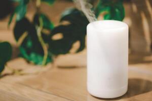 Modern essential oil diffuser on table indoors. Space for text. White aroma diffuser with copy space. photo