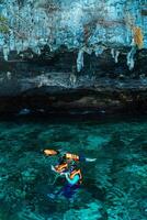 Mueang Krabi - Krabi, Thailand, 2024 - A group of tourists snorkeling around Phi-phi Island, Thailand with charming views of rocky cliffs and biota in the water photo