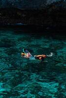 Mueang Krabi - Krabi, Thailand, 2024 - A group of tourists snorkeling around Phi-phi Island, Thailand with charming views of rocky cliffs and biota in the water photo