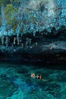 Mueang Krabi - Krabi, Thailand, 2024 - A group of tourists snorkeling around Phi-phi Island, Thailand with charming views of rocky cliffs and biota in the water photo