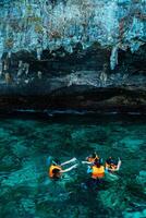 Mueang Krabi - Krabi, Thailand, 2024 - A group of tourists snorkeling around Phi-phi Island, Thailand with charming views of rocky cliffs and biota in the water photo