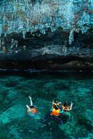 Mueang Krabi - Krabi, Thailand, 2024 - A group of tourists snorkeling around Phi-phi Island, Thailand with charming views of rocky cliffs and biota in the water photo