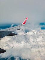 Jakarta, Indonesia, 2024 - Footage of a clear, white cloudy sky from a commercial airplane window. The view from inside the plane is a daytime sky with white clouds moving smoothly photo