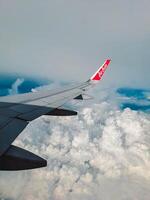 Jakarta, Indonesia, 2024 - Footage of a clear, white cloudy sky from a commercial airplane window. The view from inside the plane is a daytime sky with white clouds moving smoothly photo