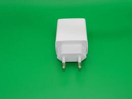 Macro photo of the white charging head on a green background. Usually use for smartphone
