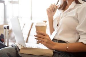 A close-up image of a businesswoman working remotely on her computer at the airport. photo