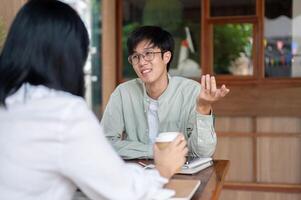 An Asian man is having an informal meeting with his colleague, discussing ideas for the co-project. photo