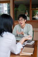 An Asian man is having an informal meeting with his colleague, discussing ideas for the co-project. photo