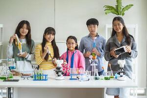 Group of children doing chemistry experiments for classroom learning photo