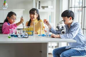 Group of school children using microscopes to study science at school photo