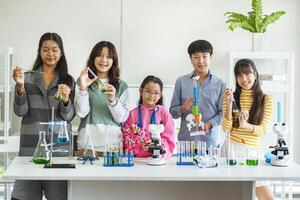 Group of children doing chemistry experiments for classroom learning photo
