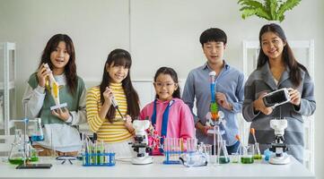Group of children doing chemistry experiments for classroom learning photo