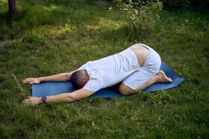 a man performs somatic exercises in the garden in the morning photo