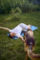 man does somatic exercises with his dog in the garden in the morning photo