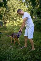 man playing with dog, tug toy, chew toy photo
