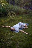 a man performs somatic exercises in the garden in the morning photo
