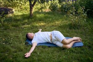 a man performs somatic exercises in the garden in the morning photo