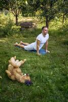 man does somatic exercises with his dog in the garden in the morning photo