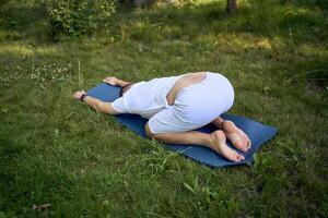 a man performs somatic exercises in the garden in the morning photo