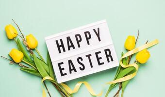 Festive spring composition yellow tulips twigs of fluffy willow and board with the text Happy Easter photo