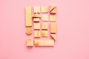 Wooden cubes lie in a row on pink background. The concept of using environmentally friendly natural materials Zero West. photo