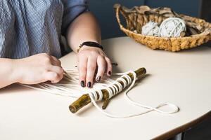 Female hands weave macrame the home workshop. Boho lifestyle. Hobby hobby concept. Selective focus horizontal frame. photo