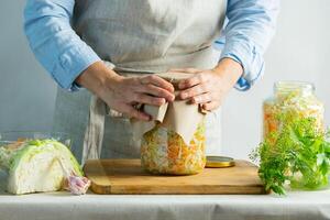 The preparation process fermentation preservation Sauerkraut on a light background. Natural rustic style. Canned food photo