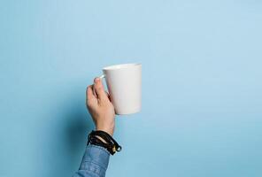 Woman holds in her hands a cup of coffee or tea drink pink background. Food drink concept. Copy space. Horizontal frame photo