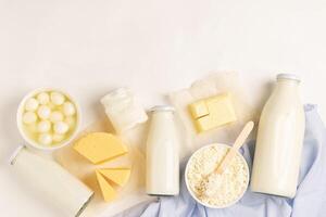Dairy and dairy products on a white background. Milk, kefir, yogurt, butter, cheese assortment. Flat layout top view. photo